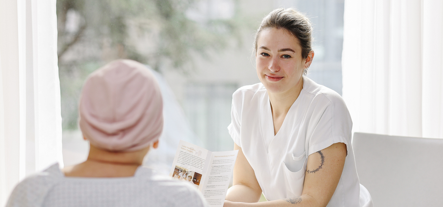 Pflegerin spricht mit Patientin